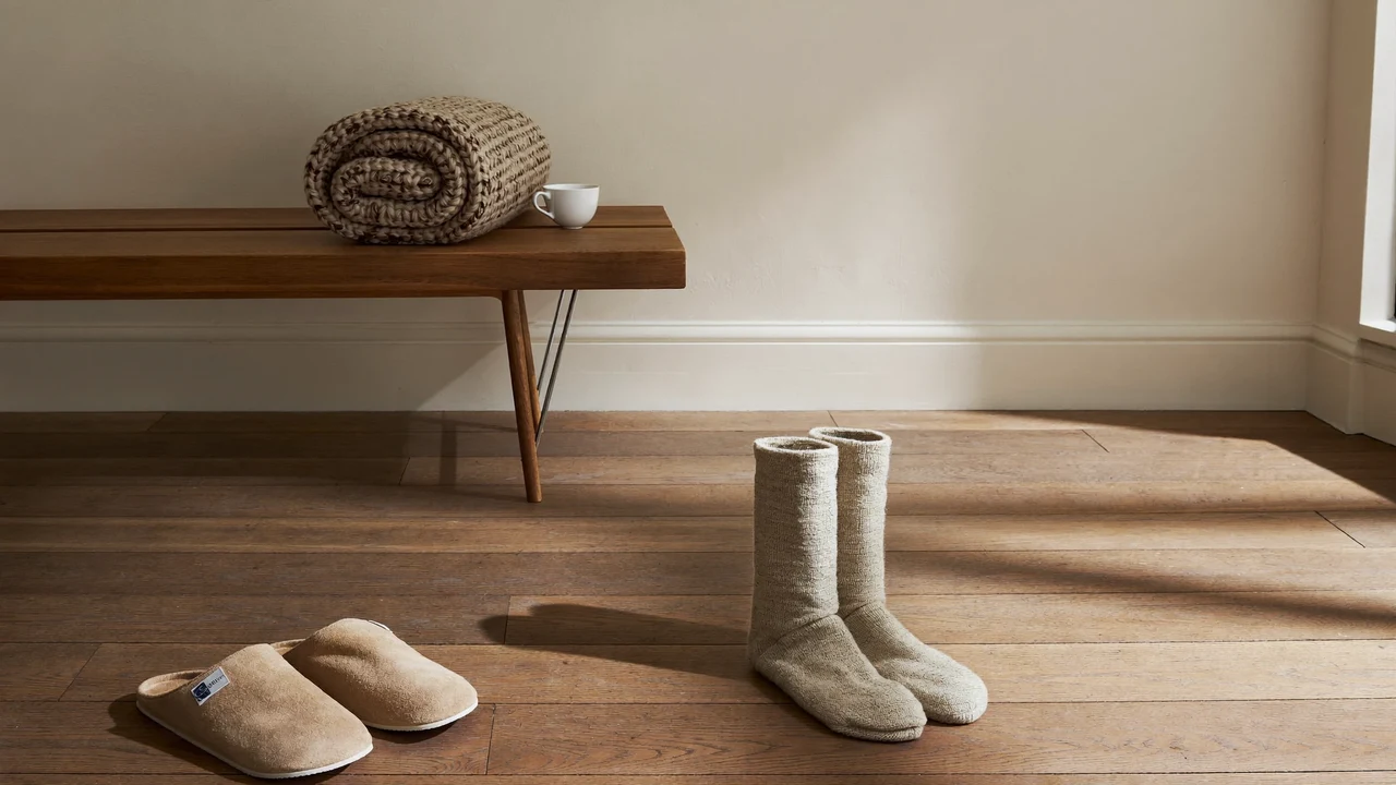 Coin de salon calme avec banc en bois, plaid plié, tasse et chaussettes en laine
